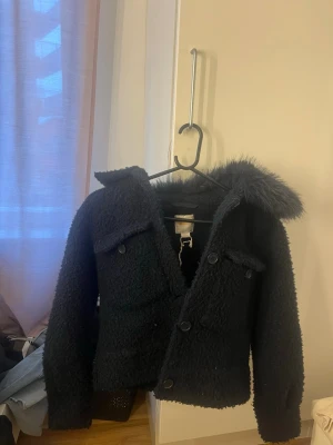 Marinblå jacka - Säljer en marinblå jacka från gina med päls på. I storlek 156/164 men passar som Xs. Från ginatricot