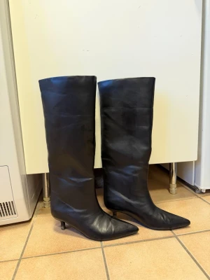 Nelly stövlar med klack - Säljer dessa stövlar från Nelly. Nypris 799kr. Använda 2-3 ggr. Det är i bra skicks men blivit 2 blåa pytte små prickar på en stövels klack som knappt syns (se sista bilden).  Tvättar av under skorna innan dem skickas så den är helt rena.