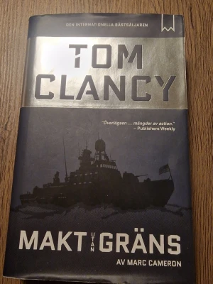 Makt utan gränsTom Clancy - Säljer boken 'Makt utan gräns' av Tom Clancy och Marc Cameron vackert inbunden i svart och silver. Omslaget har en silhuett av ett krigsfartyg och tydligalig text. Perfekt för dig som gillar polit, across och actionfyllda thrillers.