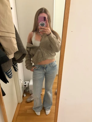 Beige hoodie från H&M - Säljer en beige hoodie från H&M i storlek XS. Hoodien har dragkedja framtill, ribbade muddar och en huva. Perfekt för en avslappnad och trendig look. Materialet är mjukt och bekvämt, passar till jeans eller leggings.