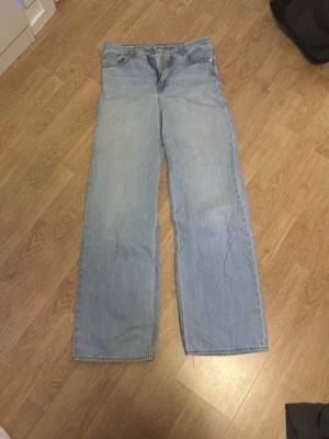 Ljusblåa raka jeans från Levi's - Ljusblå jeans från Levi's med rak passform och klassiska fem fickor. Jeansen har en avslappnad look och är tillverkade i denim. Perfekta för dig som gillar en vintage vibe och bredare ben.