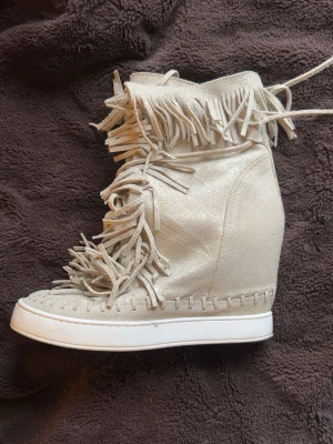 Beiga skor med fransar och kilklack - Står att det är storlek 38 men passar mig som brukar ha 39, skriv om du undrar något!