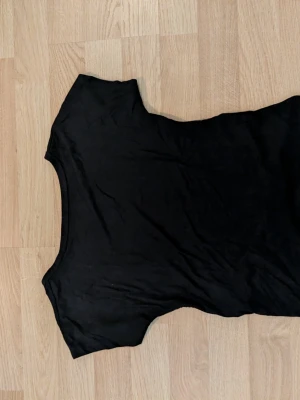 Svart kortärmad topp med öppen rygg stl. S - En basic svart topp med öppen rygg och rund halsringning stl. S 