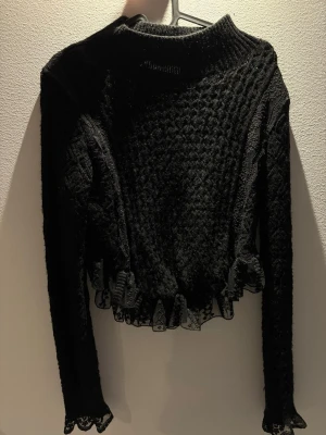 Svart stickad tröja med spetsdetaljer - Säljer en svart stickad tröja med lång ärm med en lite högre hals. Tröjan har ett unikt strukturmönster och fina spetsdetaljer i nederkant och vid ärmslut. Köpt på zara🖤