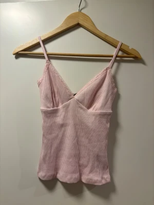 Ljusrosa ribbad spetslinne Gina tricot  - Jättefint linne, helt oanvänt. Säljer pga glömde byta mot en annan storlek. Lappen sitter kvar. Från Gina tricot. Orginalpris 229 kr