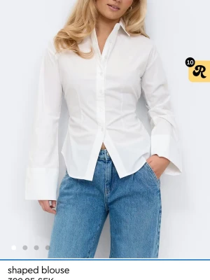 Vit skjorta med snörning från Gina Tricot - (OANVÄND) Stilren vit skjorta med markerad midja och snörning i ryggen från Gina Tricot. Skjortan har klassisk krage, långa vida ärmar och knappar framtill. Perfekt för en trendig och clean look. Strl M pga att jag ville ha oversized ärmar. men passar även XS pga banden man kan dra åt. 