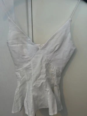 Zara topp  - Vit somrig topp från Zara i strl S. Har en dragkedja i ryggen. Knappt använd! 