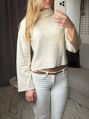Beige polotopp - Snygg beige polotopp från Vero Moda med croppad passform och vida långa ärmar. Tillverkad i mjukt material