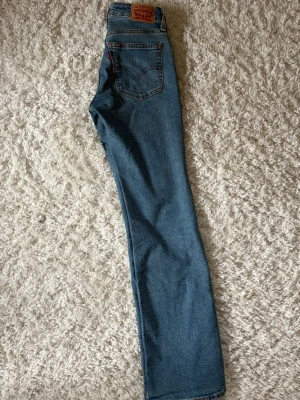 Levi's blåa lågmidjade jeans - Blåa superlow bootcut jeans från Levis. Använde fåtal gånger. Storlek 23
