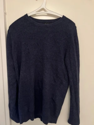 Mörkblå stickad tröja Bruun & Stengade - Snygg mörkblå stickad tröja från Bruun & Stengade. Tröjan har rund halsringning och långa ärmar, perfekt för lager på lager. Materialet är mjukt och ger en clean look som funkar till det mesta.