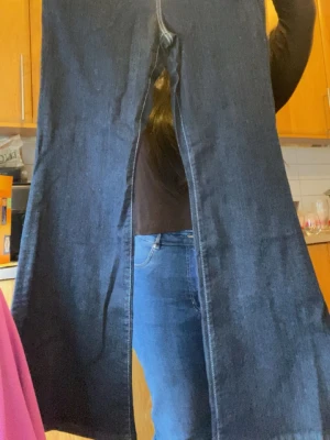 Mörkblå raka jeans - Säljer ett par mörkblå jeans med raka ben och klassisk femficksdesign. Jeansen har tydliga sömmar och bakfickor utan dekorationer. Materialet är kraftigt denim som ger en tidlös look. Perfekta till en avslappnad stil och funkar året runt. Säljer på grund av att det inte går att knäppa där framm. Original pris 499