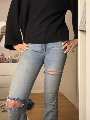Ljusblå slitna bootcut jeans - Säljer ett par ljusblå bootcut jeans med slitningar och hål vid knäna. Storlek S💞