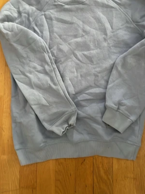 Ljusblå basic sweatshirt - En enkel ljusblå sweatshirt med rund hals och ribbade muddar vid ärmslut och nederkant. Tröjan har en avslappnad passform och är tillverkad i mjukt bomullsmaterial. Perfekt för en chill och casual stil.