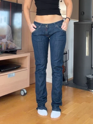 Mörkblå Lågmidjade replay jeans  - Säljer ett par mörkblå jeans med rak passform och låg midja. Klassisk femficksmodell med knappgylf och snygga kontrastsömmar. Perfekta till en avslappnad stil och passar till det mesta. Jag är 163 cm för referens. Storlek W31. Har två hål inuti jeansen men syns inte utanpå. Se sista bild 
