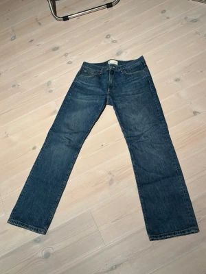 Jeanerica sm010 i mörkblå 31/34 - Jeanerica sm010 jeans i mörkblå denim med raka ben och femficksmodell. Jeansen har normal passform och är tillverkade i slitstarkt bomullsmaterial. Perfekta för dig som gillar en tidlös och enkel stil.
