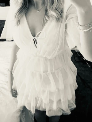 Vit kort tyllklänning med volanger - Säljer denna fina klänning då den inte kommer till användning. Perfekt för skolavslutning och student! oanvänd med prislapp kvar. Pris kan diskuteras☺️