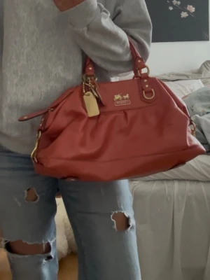 Unik läderväska från Coach - Supercool och rymlig coach väska som passar perfekt att ha som skolväska men flera fack och innerficka, unik och i hyfsat skick.  Finns små defekter som ni kan se på bilderna, guld”lädret” har liksom flagnat av på lappen på insidan och på tagen som hänger men inget som syns när man bär den ❤️❤️ kan också tänka mig att byta mot någon annan väska av samma storlek och pris 🥰  Liknar Marc by Marc jacobsväskan i modellen!!