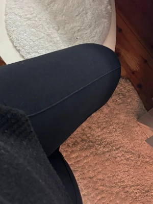 Svarta bootcut leggings i lite tjockare material  - Säljer ett par svarta leggings med bootcut-modell. De är stretchiga och sitter tight över låren men har utsvängda ben nertill. Perfekta till oversized tröjor eller hoodies. Materialet känns mjukt och följsamt, troligtvis bomull eller bomullsblandning.