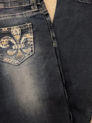 Mörkblå jeans från Gina Tricot - Säljer ett par mörkblå jeans från Gina Tricot i storlek S. Klassisk femficksmodell med vita kontrastsömmar och normal midja. Jeansen har raka ben och är tillverkade i ett mjukt denimtyg som sitter snyggt på kroppen.