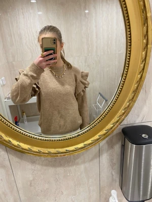Beige stickad tröja med volang H&M - Säljer en beige stickad tröja från H&M med volangdetaljer längs ärmarna. Storlek 12-14 år 158-164. Super fin men kommer inte till användning. 