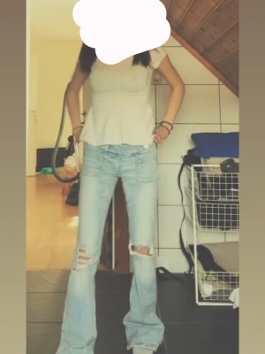 Ljusblå bootcut jeans - Säljer ett par ljusblå bootcut jeans med slitningar och hål på knäna. Jeansen har låg midja, säljer pga dem är förlänga och lite för stora🫶🏼använt hemma en gång, aldrig gått ut med dem bara testat och nu ligger dem i garderoben. 