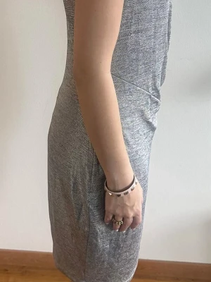 Silver ärmlös kortklänning - Snygg ärmlös klänning i silverfärgad polyester med diskret glittrig yta. Klänningen har en kroppsnära passform och dragkedja baktill för enkel på- och avtagning. Perfekt för dig som gillar stilrena och moderna plagg. Passsr 38 och 40, stretchigt material.