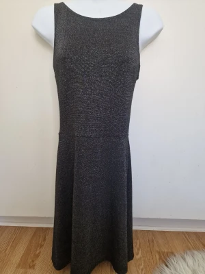 Glittrig grå/svart klänning - Snygg svart klänning med glittrigt tyg och ärmlös design. 