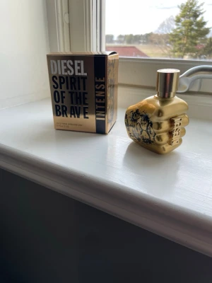 Diesel Spirit of the Brave Intense - Diesel Spirit of the Brave Intense är en parfym med en unik flaska formad som en gyllene knytnäve med svart motiv. Förpackningen är guld och svart med tydlig logotyp. Perfekt för dig som vill ha en kraftfull och modern doft.