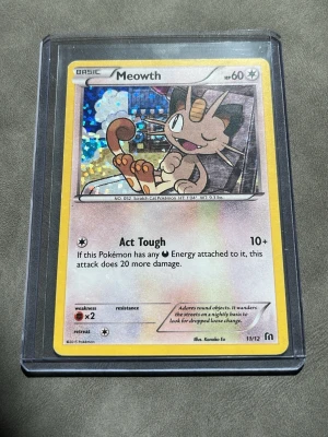 Meowth Pokémonkort holografiskt - Säljer ett holografiskt Meowth Pokémonkort från 2016, nummer 11/12. Kortet har gul ram och motiv av Meowth som sitter avslappnat. Kortet är inplastat i skyddsfodral och har glittrande effekt på bilden. Perfekt för samlare! 2016 Mcdonalds kort med värde upp mot 370kr