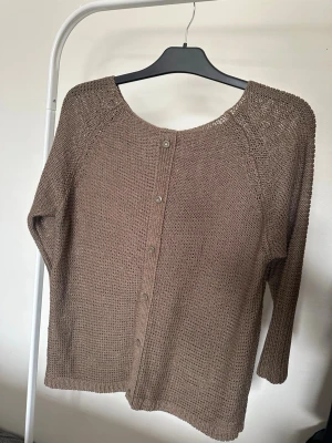 Beige stickad kofta med knappar - En enkel och stilren beige stickad kofta med rund hals och knappar framtill. Koftan har trekvartsärmar och är gjord i ett mjukt stickat material som känns skönt mot huden. Perfekt att slänga på sig när det är lite kyligt.