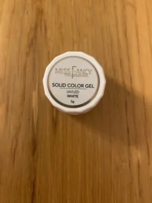 Miss Fancy Solid Color Gel White - Solid Color Gel från Miss Fancy i färgen vit. Gelen är anpassad för UV/LED-lampa och kommer i en liten burk på 5g. Perfekt för att skapa snygga och täckande naglar med en klassisk vit finish.