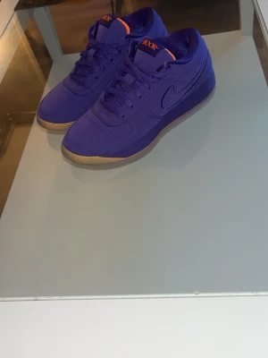 Nike Book 1 lila sneakers - Nike Book 1 “Sunset”   Säljer ett par stilrena basketskor från Devin Booker – modellen Book 1 “Sunset”. Riktigt snygg design och en populär signatursko.  Skorna är använda max 3–4 gånger och är i mycket fint skick, vilket syns tydligt.  De är väldigt bekväma med mjukt material på insidan och känns lätta på foten, vilket gör att du kan spela utan att de känns tunga eller störande.