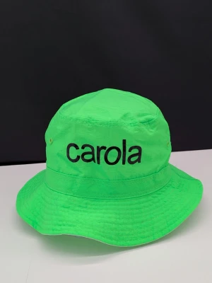 CAROLA HÄGGKVIST hatt buckethat fiskarhatt - Neongrön hatt med Carola tryck Hatten är vändbar One size/ en storlek passar alla  * Helt oanvänd * Officiell merchandise från turnén när det begav sig 