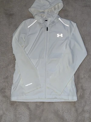 Under armour windbreaker jacka  - Otroligt fint skick inga defekter alls. Reflektiv och perfekt till våren/sommaren