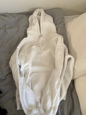 Vit hoodie från Bik Bok med huva - Säljer denna superfina hoodie från Bik Bok i storlek XS. Hoodien har en stor luva med ribbade muddar och en magficka. Materialet är mjukt och bekvämt, perfekt att slänga på sig när det är lite kyligt. 💗