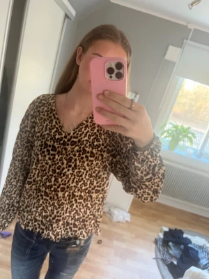 Leopardmönstrad blus från Saint Tropez - Snygg leopardmönstrad blus från Saint Tropez med v-ringning och långa ärmar. Tillverkad i ett tunt, luftigt material som ger en avslappnad och trendig look. Perfekt för dig som vill sticka ut med ett djurmönster💓 använd fåtal gånger💓