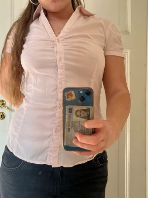 Ljusrosa kortärmad blus - Söt ljusrosa blus, har tyvärr en fläck som inte går bort därav priset