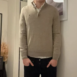 Beige halvzip i merinoull från Morris - Säljer en stilren beige tröja från Morris i mjuk merinoull. Tröjan har en klassisk design som passar till många tillfällen. Jag är 187cm och väger 80 kg Skicket är 10/10, fick den i julklapp men den är för liten så har använt den 3 gånger kanske. Nypris 1800kr