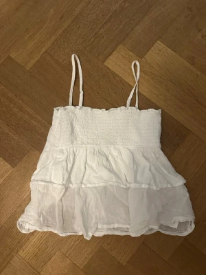 Vit volang linnetopp med smala band - Jättesöt vit topp med volanger. Toppen passar perfekt till sommaren och är nästan oanvänd. I storlek ”134-140” 🤍 