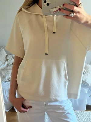 Kortärmad hoodie - Kortärmad beige/ krämvit hoodie. Sååå tunt och skönt material och använd fåtal gånger!