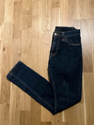 Nudie Jeans - Klassiska Nudie Jeans för män, Storlek Waist 27/Lenght 30. Byxorna är nyskick inga skador/slitage. Hör av dig vid intresse/frågor. PRIS KAN DISKUTERAS!