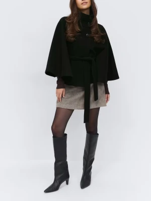 Svart cape-kappa med knytband - Stilren svart cape-kappa med knappar framtill och knytband i midjan. Kappan har vida ärmar och hög krage, vilket ger en cool och modern siluett. Perfekt för dig som vill ha en trendig och unik look. Materialet ser ut att vara ullblandning.