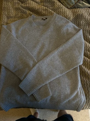 Ljusblå stickad tröja från Uniqlo - Säljer en stilren ljusblå stickad tröja från Uniqlo. Tröjan har rund halsringning, långa ärmar och ribbade muddar vid ärmslut och nederkant. Perfekt basplagg i mjukt material som passar till det mesta. Aldrig använd 