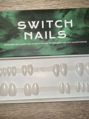 Switch Nails White Pearl Almond Short - Press-on naglar från Switch Nails i modellen White Pearl. Naglarna har en snygg pärlvit färg och kommer i formen almond short. Tillverkade av återvunnet material och kan återanvändas. Perfekt för dig som vill ha salongskänsla snabbt hemma. Säljes utan tillbehör. Klisterrester i 4:orna och i 11:orna. 