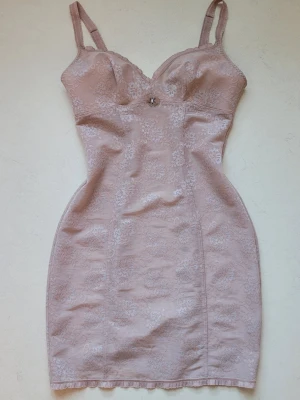 Vintage Y2K Intimissimi klänning - Säljer en ljusrosa figurnära spetsklänning från Intimissimi. Klänningen har diskreta spetsmönster av blommor och välgjorda sömmar som ger en hourglass figur. Storlek XS/S, inga defekter. Justerbara axelrämmar med söta mönster och en liten rosett mellan bysten. Det behövs ingen bh, då det finns ett tjockt, mjukt tyg bakom bröstpartiet och en liten bygel på sidan. Resten av klänningen är lätt genomskinlig för en romantisk look💕 (Sista bilden är en annan klänning som sitter liknande)