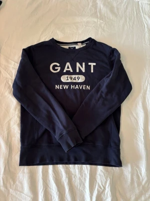 Mörkblå sweatshirt från GANT - Snygg mörkblå sweatshirt från. Tröjan har rund halsringning, långa ärmar och ribbade muddar. Perfekt för en avslappnad och stilren look.
