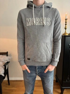 Grå hoodie från Morris med tryck - Säljer en riktigt najs grå hoodie från Morris med en vit Morris logga på bröstet. Jag säljer den för 349kr! om du har några funderingar.