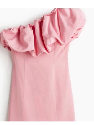 Rosa offshoulder klänning med volang - Snygg rosa kortklänning med offshoulder och stor volang upptill. Klänningen har en figurnära passform och är perfekt för dig som vill sticka ut. Tillverkad i ett slätt material som ger en elegant känsla.