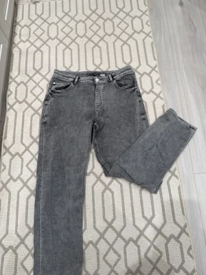 Grå raka jeans - Snygga grå jeans med raka ben och klassisk femficksdesign. Jeansen har normal passform. Perfekta för en avslappnad och stilren look.