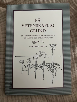 På vetenskaplig grund av Corrado Matta - Boken 'På vetenskaplig grund' av Corrado Matta är en vetenskapsteoretisk vägledning för lärare och lärarstudenter. Omslaget är vitt med gråa ränder och illustration av växtrötter. Perfekt för dig som pluggar pedagogik eller utbildningsvetenskap.